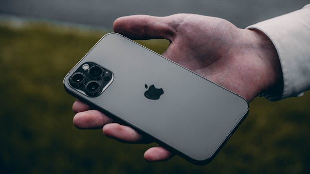 A person holding a sleek, modern smartphone in an outdoor setting, showcasing its design.