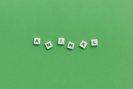 Scrabble tiles spelling 'animal' on a vibrant green background, providing conceptual space.