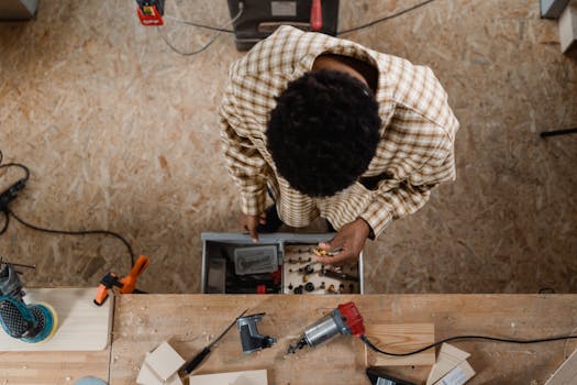 Top view of a craftsman organizing tools in a woodworking shop.