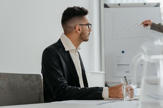 Professional male analyzing growth chart during modern office meeting session.
